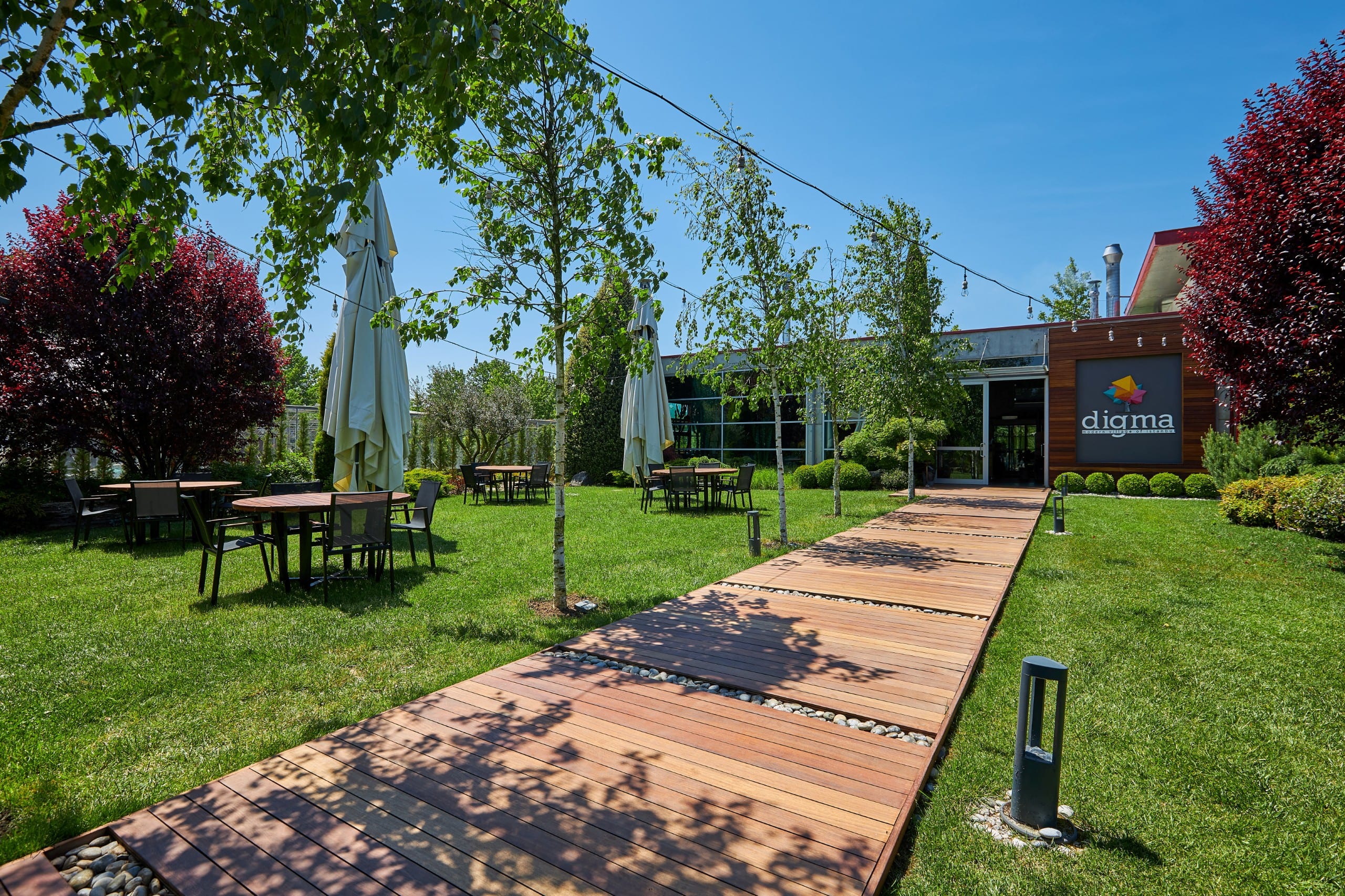 Restorana uzanan ahşap bahçe yolu ve Digma tabelası
